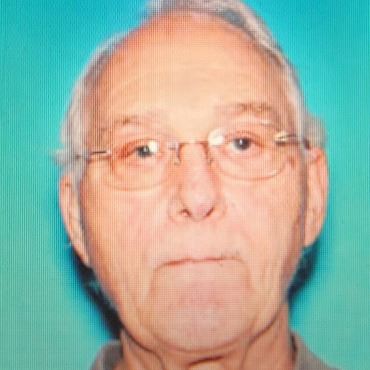 Portrait photo of older white man with white hair and glasses.