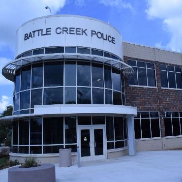 Battle Creek Police Department Station, with rounded corner and many windows.