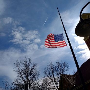 A photo of the U.S. flag at half-staff in front of the Battle Creek Police Department station.