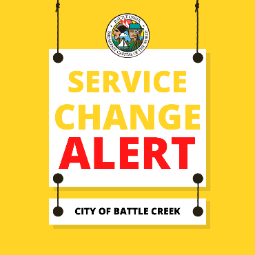 Bright gold square with city logo at top. White hanging signs say 