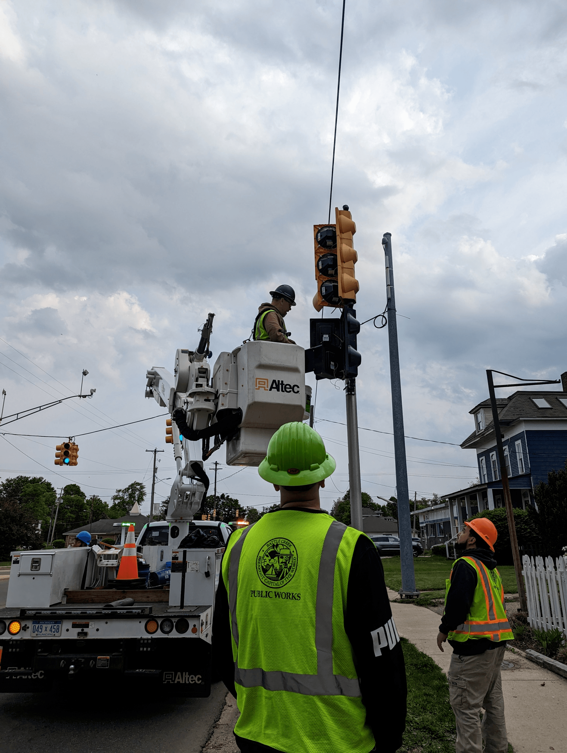 City sign and signal crew members work to fix a traffic signal.